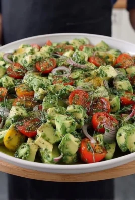Colorful avocado salad with fresh vegetables and dressing