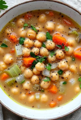 A bowl of delicious chickpea and white bean soup garnished with herbs