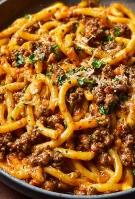 Creamy beef pasta served in a bowl with herbs and grated cheese