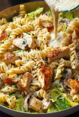 Plate of creamy chicken pasta garnished with herbs and cheese