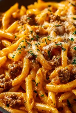 Creamy high protein beef pasta served in a bowl with herbs