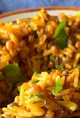 Bowl of easy Mediterranean lentils and rice, garnished with fresh herbs.