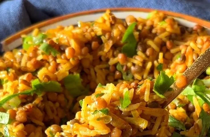 Bowl of easy Mediterranean lentils and rice, garnished with fresh herbs.