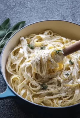 Delicious plate of Fettuccine Alfredo topped with parsley and grated cheese