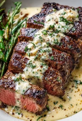 Juicy Garlic Butter Steak with creamy Parmesan sauce on a plate.