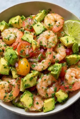 Colorful healthy shrimp avocado salad with fresh ingredients and dressing.
