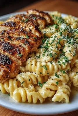 Honey Garlic Chicken Pasta topped with herbs and garlic cloves on a plate