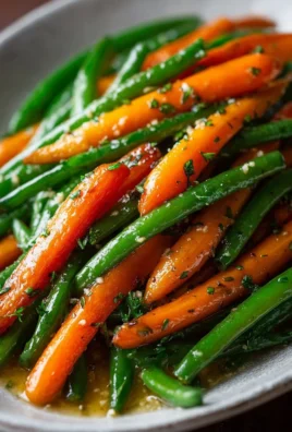Honey glazed carrots served with green beans on a white plate