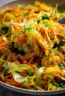 Plate of Jamaican cabbage garnished with spices and peppers.