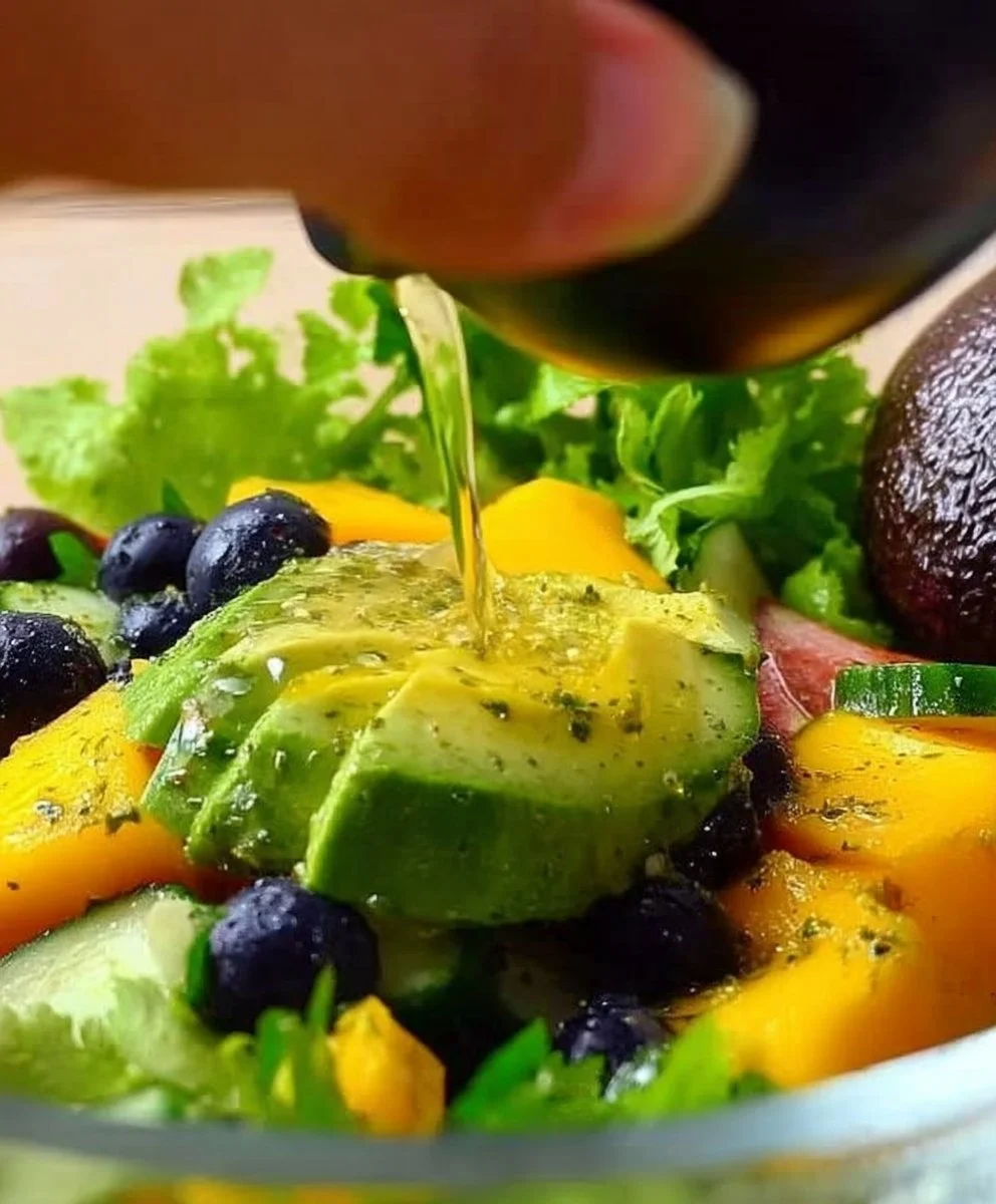 Mango cucumber salad topped with blueberries and avocado in a vibrant bowl