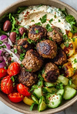 Mediterranean beef meatball bowl with fresh vegetables and herbs