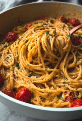 Delicious roasted tomato and garlic ricotta pasta dish garnished with fresh herbs.