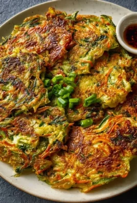 Plate of delicious Vegan Vegetable Pancakes topped with fresh herbs