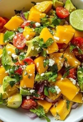 Avocado mango salad with zesty lime dressing on a wooden table