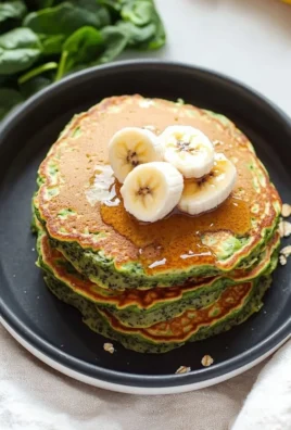 Blender Banana Spinach Pancakes stacked with fresh bananas and spinach