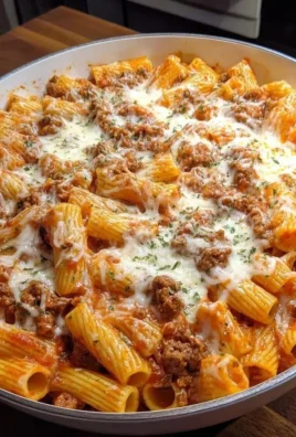 Cheesy baked rigatoni with ground beef served in a casserole dish.