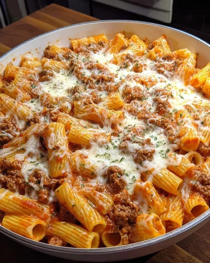 Cheesy baked rigatoni with ground beef served in a casserole dish.