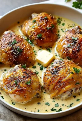 Creamy garlic chicken thighs served with herbs and a side of vegetables.