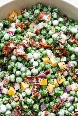 Easy cold pea salad with bacon served in a bowl, garnished with herbs
