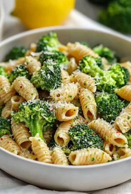 A plate of easy healthy broccoli pasta garnished with herbs and cheese.
