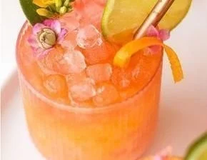 Colorful Pineapple Mango Rum Punch in a glass with tropical fruits