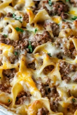 Sour Cream Beef Noodle Casserole topped with cheese and garnished with parsley
