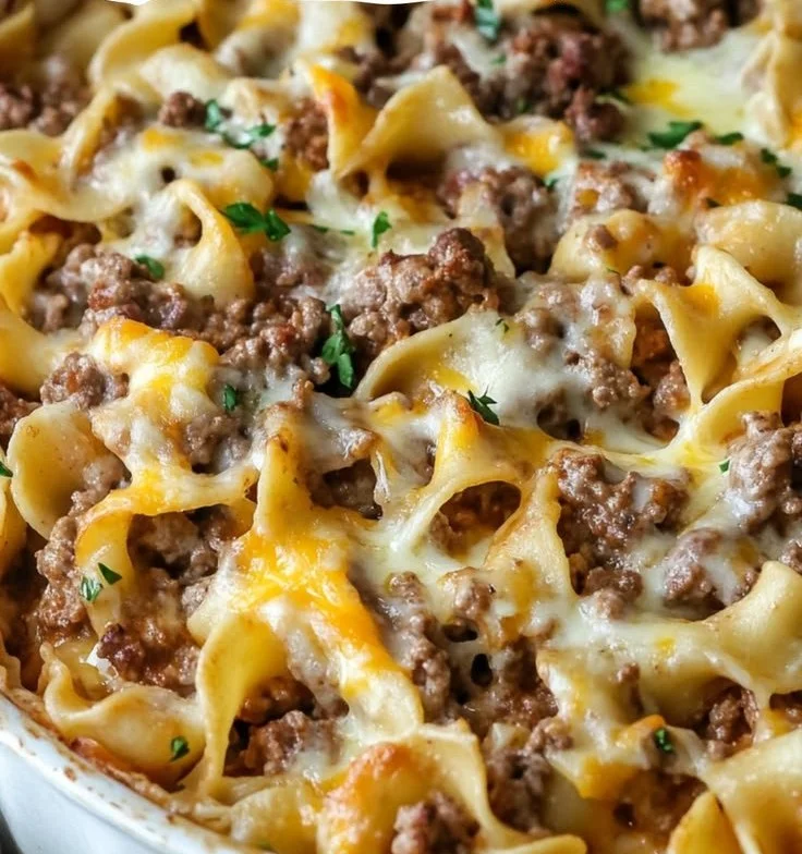 Sour Cream Beef Noodle Casserole topped with cheese and garnished with parsley