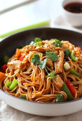 Bowl of Spicy Chicken Hakka Noodles garnished with fresh vegetables