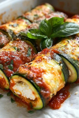 Delicious Zucchini Rollatini served on a plate with fresh herbs and cheese.